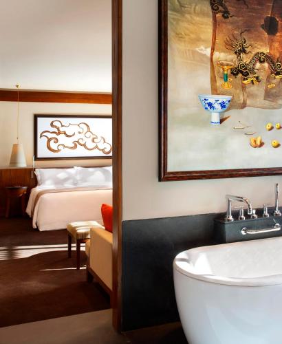 a bathroom with a bath tub and a bedroom with a bed at The St. Regis Lhasa Resort in Lhasa