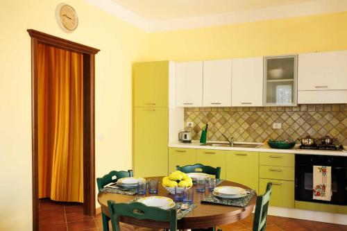 a kitchen with a wooden table with chairs and a dining room at La Terrazza sul Mare in Eraclea Minoa
