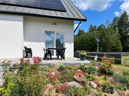 a house with a solar roof with a table and chairs at Gościniec Wigry 2 in Walne