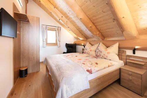 a bedroom with a large bed in a attic at Chalet Tannenhaus I in Maltaberg