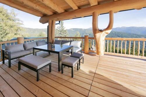 a porch with a table and chairs on a deck at Chalet Tannenhaus I in Maltaberg