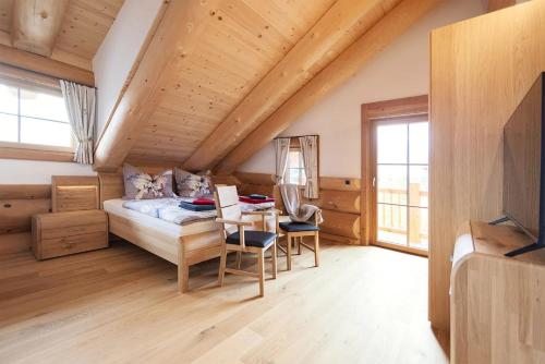 a bedroom with a bed and a table and chairs at Chalet Tannenhaus I in Maltaberg