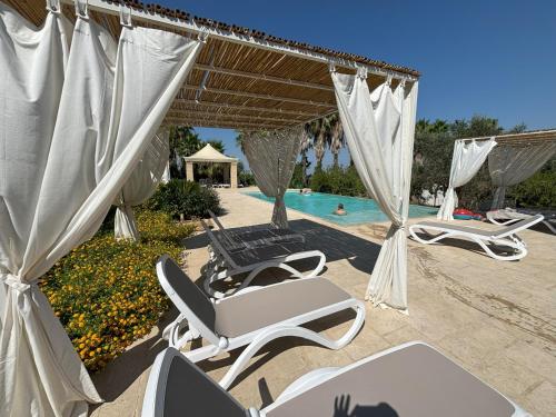 a group of lounge chairs and a swimming pool at WHITE POOL 5P Matino - Gallipoli in Matino