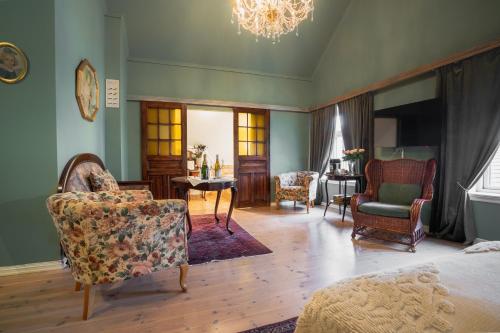 a living room with furniture and a chandelier at GamlaVærket Gjæstgiveri og Tracteringssted in Sandnes