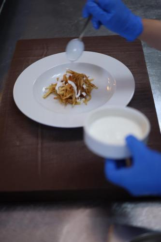 a person is eating food on a plate on a table at Hilton Garden Inn Konya in Konya
