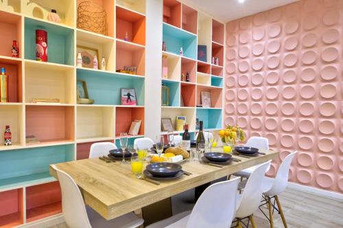 une salle à manger avec une table en bois et des chaises blanches dans l'établissement Bluestay 149 - Spacieux appartement Paris centre, à Paris