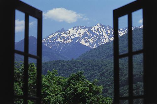 a view of a snow covered mountain from a window at Hodakaso Yamano Hotel in Takayama