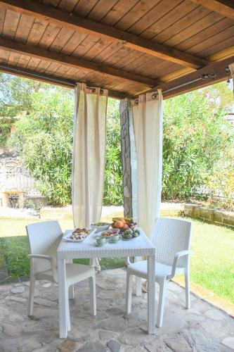 a white table and chairs on a patio at Domu Virginia in Castiadas