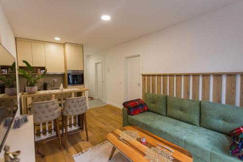a living room with a couch and a kitchen at Aparthotel Phoenix in Bjelašnica
