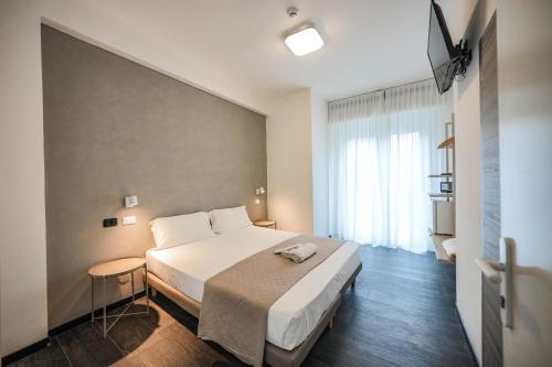 pokój hotelowy z łóżkiem i oknem w obiekcie SOMA w Rimini