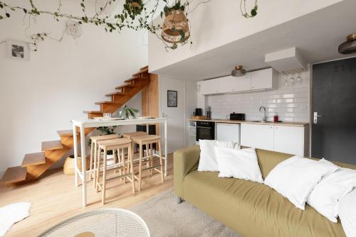 un salon avec un canapé et une cuisine dans l'établissement La forêt Suspendue - T2 douillet avec Parking Gratuit, à Toulouse