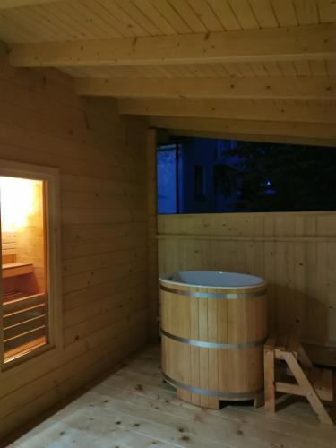 a wooden sauna with a tub in the corner at Willa Hamernik AGROTURYSTYKA in Tylicz