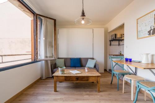 un salon avec une table et un canapé dans l'établissement UniqueAppart - Gare Saint Charles, à Marseille