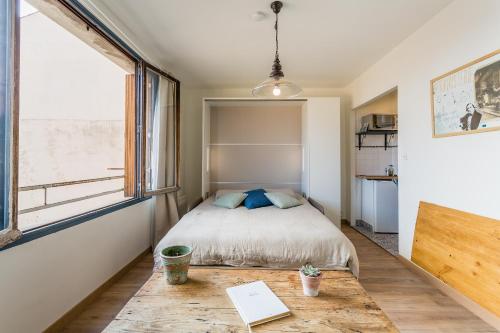 - une petite chambre avec un lit et une table dans l'établissement UniqueAppart - Gare Saint Charles, à Marseille