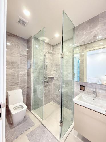 a bathroom with a shower and a toilet and a sink at 1BR l 10 Mins from Siam Paragon l Rooftop Pool in Bangkok