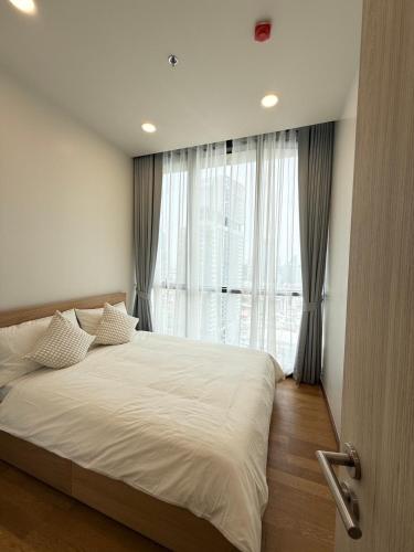 a bedroom with a large bed and a large window at 1BR l 10 Mins from Siam Paragon l Rooftop Pool in Bangkok