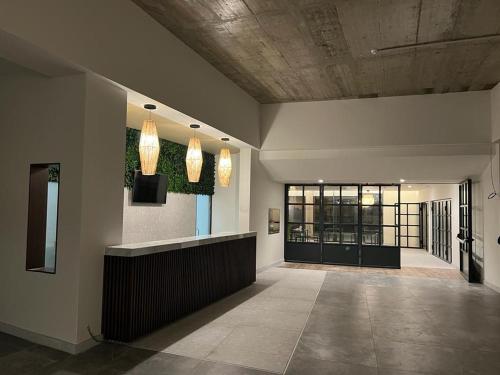 a lobby with a reception desk and lights on the wall at Porto Covo Praia Hotel & SPA in Porto Covo