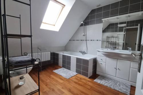 une salle de bain avec un lavabo et une baignoire dans l'établissement Maison du Fort Vallières - Bois des forts, à Boomkens