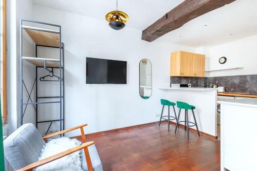 - une cuisine avec un comptoir et deux tabourets dans une pièce dans l'établissement Studio intimiste au cœur du Marais historique, à Paris