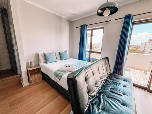 ケープタウンにあるCape Mae Apartment Hotelのベッドと大きな窓のある寝室