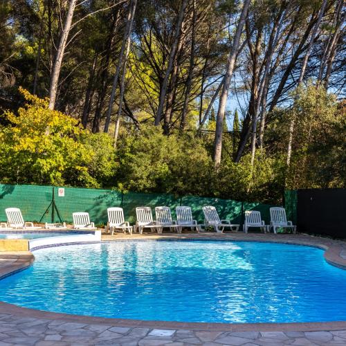 un groupe de chaises assises autour d'une piscine dans l'établissement Le Sissi - Havre de Paix à Sanary, à Sanary-sur-Mer