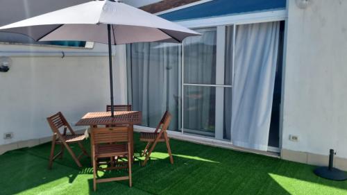 a patio with a table and chairs and an umbrella at La Dea Busa in Canosa di Puglia