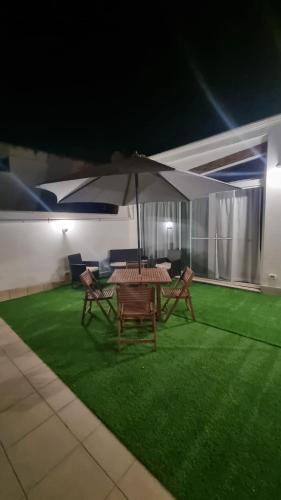a patio with a table and chairs and an umbrella at La Dea Busa in Canosa di Puglia
