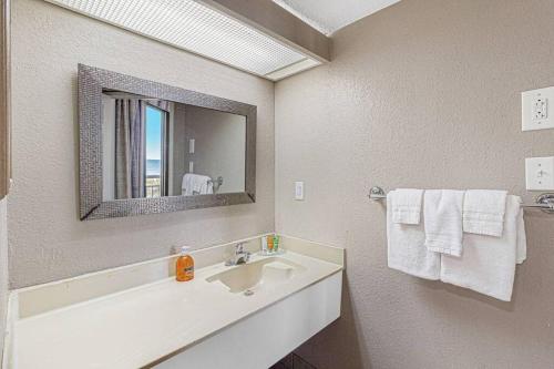 a bathroom with a sink and a mirror and towels at High Tides & Good Vibes in our Oceanfront Studio! PG 326 in Myrtle Beach