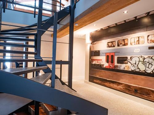 un escalier dans une maison avec une fresque murale représentant le train dans l'établissement Chalet Bonami 450 m2 salle cinema jacuzzi hammam, à Chamonix-Mont-Blanc