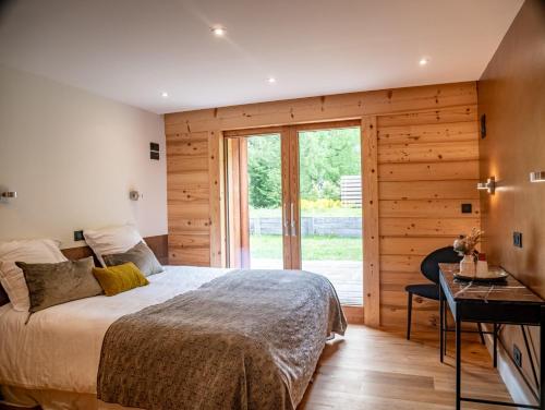une chambre avec un lit et une porte coulissante en verre dans l'établissement Chalet Bonami 450 m2 salle cinema jacuzzi hammam, à Chamonix-Mont-Blanc