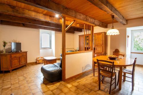 une cuisine et un salon avec une table et un canapé dans l'établissement Gite de canilhac, à Canilhac