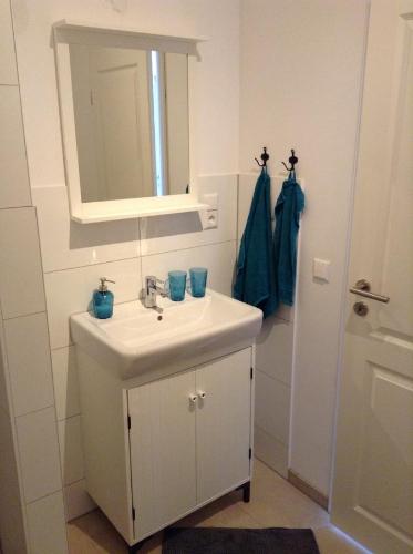 a white bathroom with a sink and a mirror at Schlaf aus im Schwedenhaus in Eimeldingen