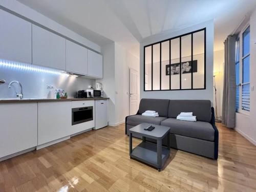 un salon avec un canapé et une cuisine dans l'établissement Grand Studio 2 pers République Bastille Paris 3, à Paris