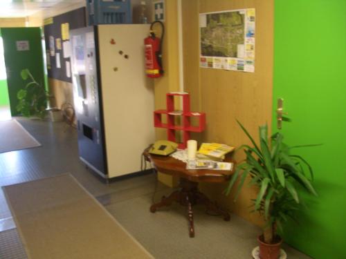 a room with a refrigerator and a table in a room at Gästedorf Waldheimat in Langenwang