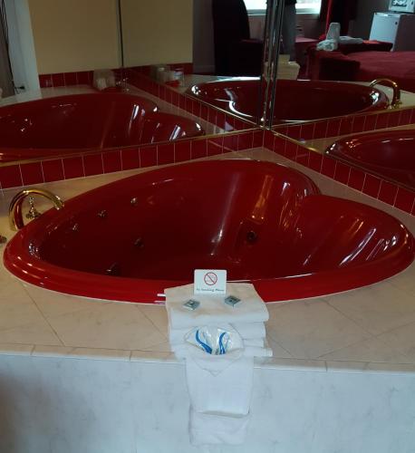 a red bath tub with a pile of towels at New Relax Inn Bridgeview in Bridgeview