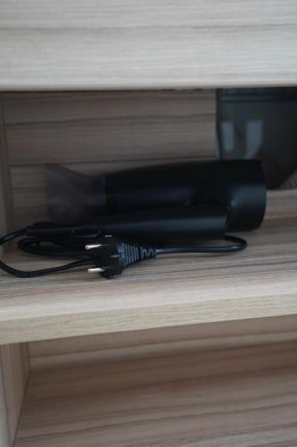 a black hair dryer sitting on a shelf at Titi House Borsa in Borsa