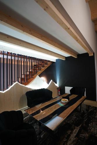 a living room with a wooden table and a staircase at Titi House Borsa in Borsa