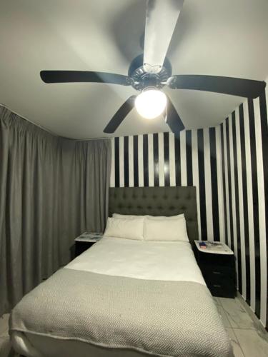 a bedroom with a bed with a ceiling fan at Durban Beach Views at 10 South in Durban