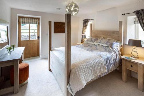 a bedroom with a large bed and a desk at Stay Lambing Live in Kirkby Stephen