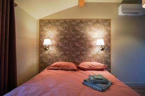 ein Schlafzimmer mit einem Bett mit zwei Kissen und zwei Lampen in der Unterkunft Le Petit Paradis de Pruzilly in Pruzilly