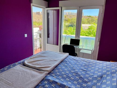 a bedroom with a bed and a desk with a laptop at Townhouse med takterrass i Costa Hispania in Gran Alacant