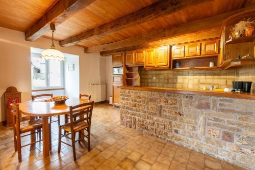 - une cuisine avec une table et un mur en pierre dans l'établissement Gite de canilhac, à Canilhac