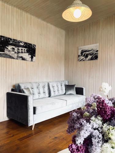 a living room with a white couch and some flowers at Pūjalgi in Ēdole