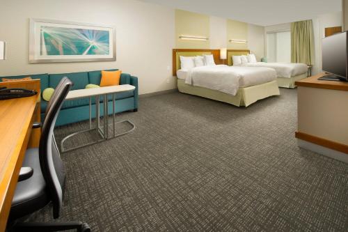 a hotel room with two beds and a couch at SpringHill Suites by Marriott Bridgeport Clarksburg in Bridgeport