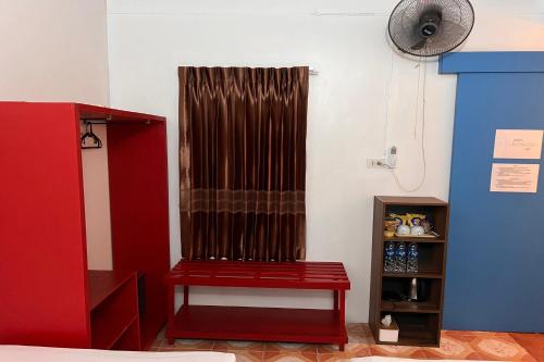 a red bench in a room with a fan at Phuket Old Town Hostel in Phuket Town