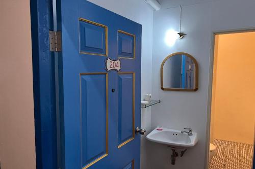a bathroom with a blue door and a sink at Phuket Old Town Hostel in Phuket Town