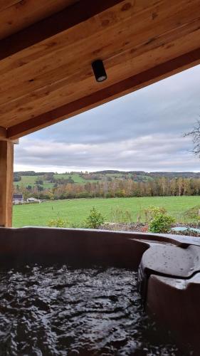 a view from the inside of a wooden house with water at Lu Bê mont in Stavelot