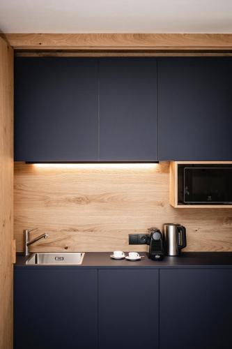 a kitchen with a sink and a microwave at The Post Mountain Residence in Dobbiaco