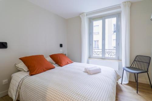 a bedroom with a bed with orange pillows and a window at Le Terracotta - T2 Design - Métro, RER & Jardin in Vincennes