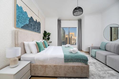 a bedroom with a large bed and a couch at Moderne 1BR with a lovely marina view in Dubai